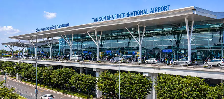 Tan Son Nhat Airport main terminal exterior with glass facade and traffic, Vietnam