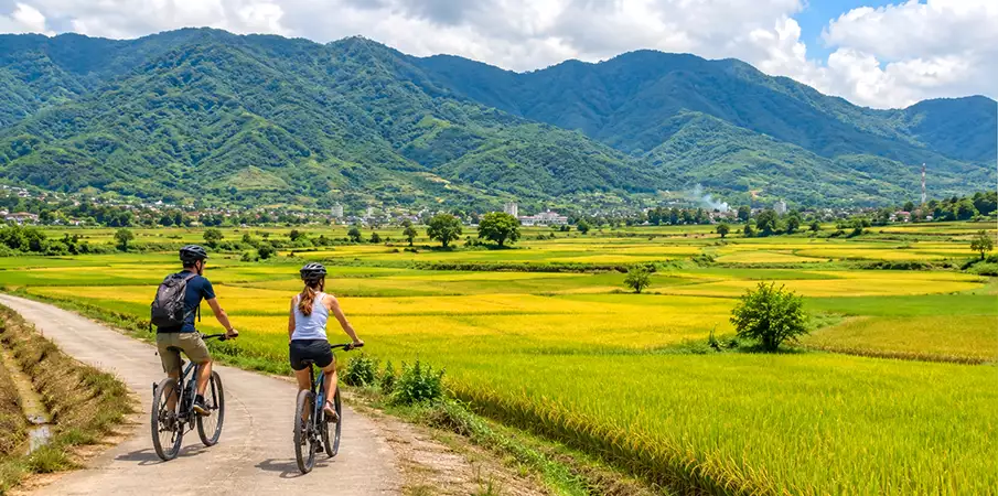 Cycling in Muong Thanh Valley, Dien Bien Phu Two tourists cycling through Muong Thanh Valley near Dien Bien Phu, Vietnam