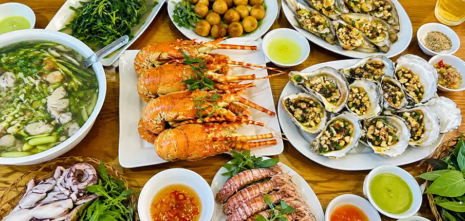 Fresh seafood including lobster, oysters, squid, and shellfish served on Co To Island in Quang Ninh Province, Vietnam