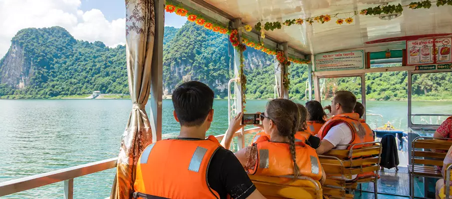 Tourists Enjoying a Boat Tour on Hoa Binh Lake, Northern Vietnam Tourists enjoying a scenic boat tour across Hoa Binh Lake surrounded by limestone mountains in northern Vietnam